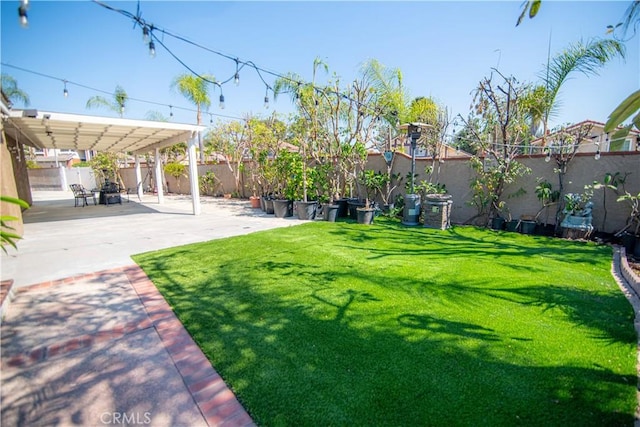 view of yard featuring a patio area, a pergola, and a fenced backyard