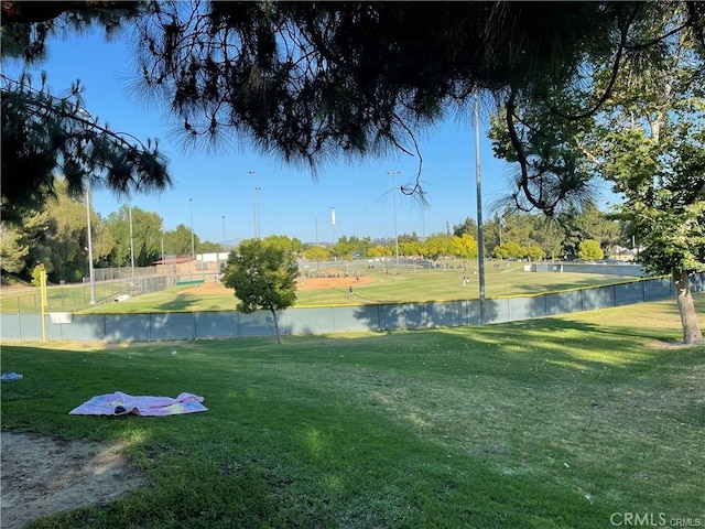 surrounding community with a water view, a lawn, and fence