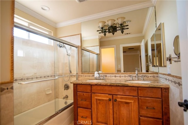 bathroom with ornamental molding, shower / bath combination with glass door, and a sink