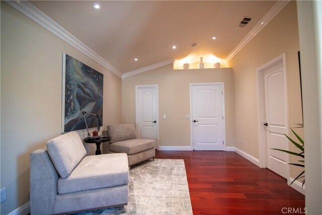 living area with vaulted ceiling, wood finished floors, baseboards, and ornamental molding