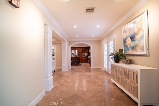 corridor with visible vents, baseboards, ornamental molding, arched walkways, and ornate columns