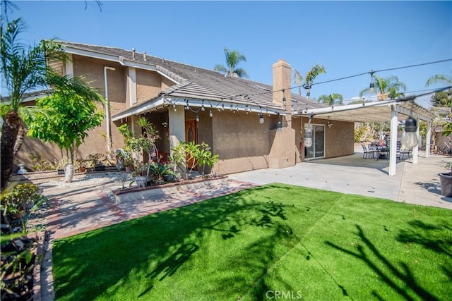 back of property featuring stucco siding, a lawn, a pergola, a patio, and a chimney