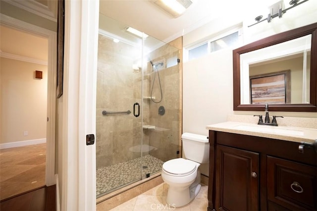 bathroom featuring vanity, a stall shower, tile patterned flooring, crown molding, and toilet