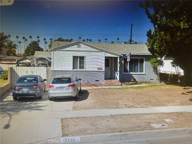 view of front of property with crawl space and fence