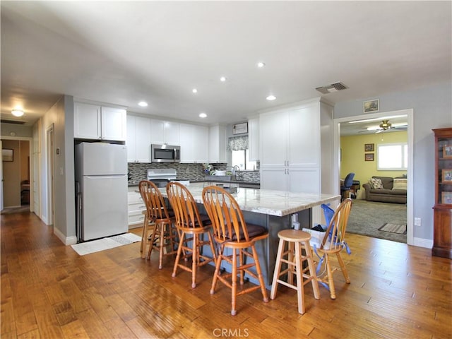 dining space with recessed lighting, visible vents, ceiling fan, baseboards, and hardwood / wood-style flooring