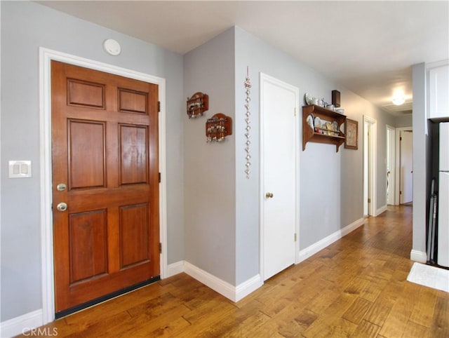 foyer featuring light wood-type flooring and baseboards