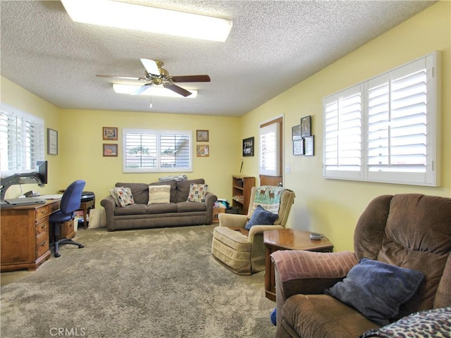 carpeted living room with ceiling fan and a textured ceiling