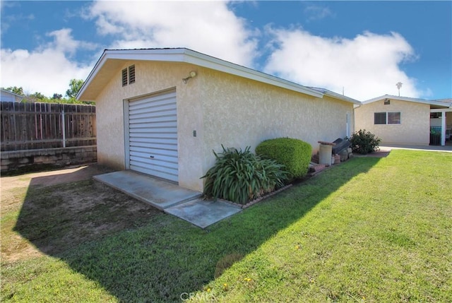 exterior space with fence, a lawn, and stucco siding