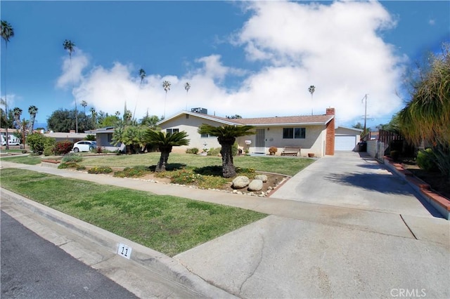 ranch-style home with a front yard and concrete driveway