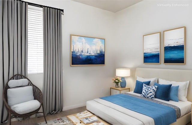 bedroom featuring baseboards and wood finished floors