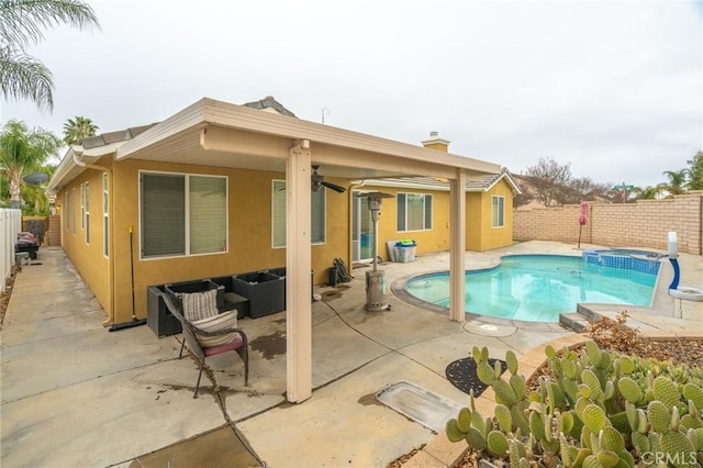 view of swimming pool featuring a patio area, a pool with connected hot tub, outdoor lounge area, and a fenced backyard