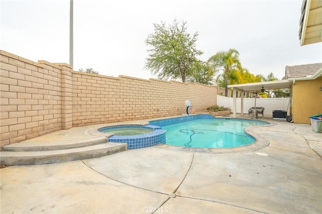 view of pool featuring a patio area, a fenced backyard, and a pool with connected hot tub