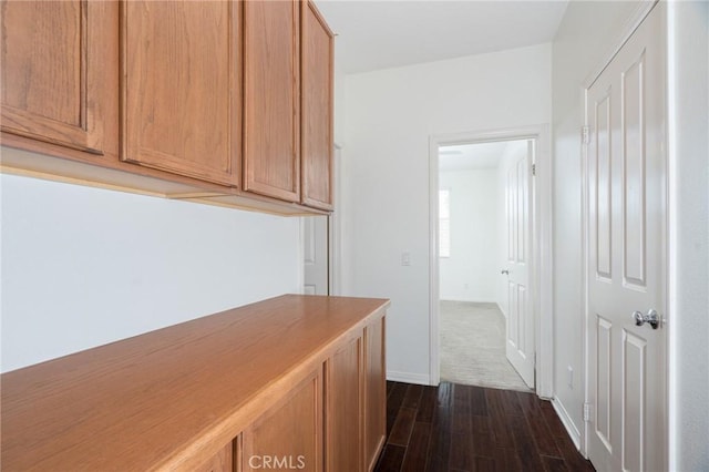 hallway featuring dark wood-style floors and baseboards