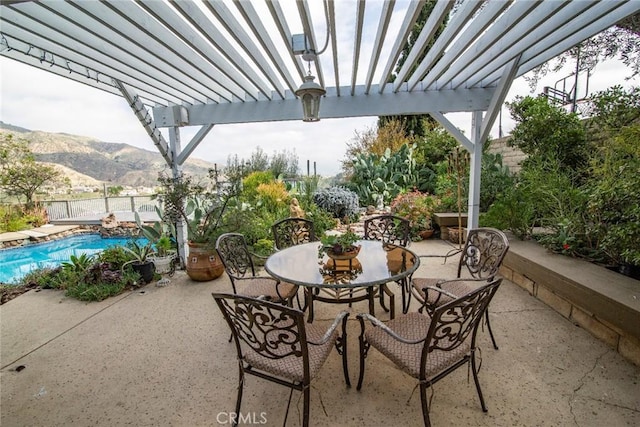 view of patio / terrace with a fenced in pool, outdoor dining space, a mountain view, fence, and a pergola