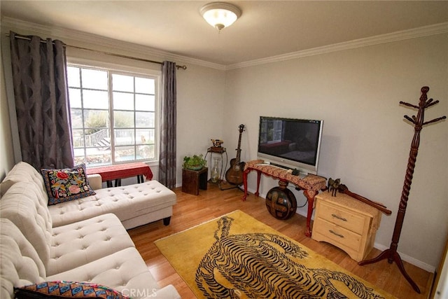 living room featuring baseboards, ornamental molding, and wood finished floors