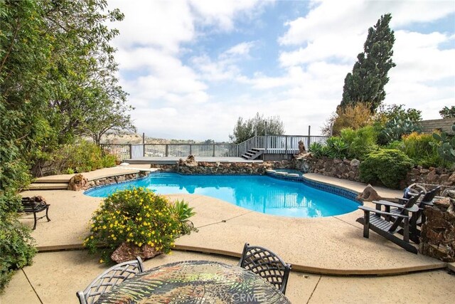 outdoor pool with a patio and fence