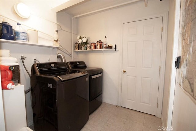 laundry room with light tile patterned floors, laundry area, and washing machine and clothes dryer