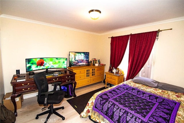 bedroom with ornamental molding and wood finished floors