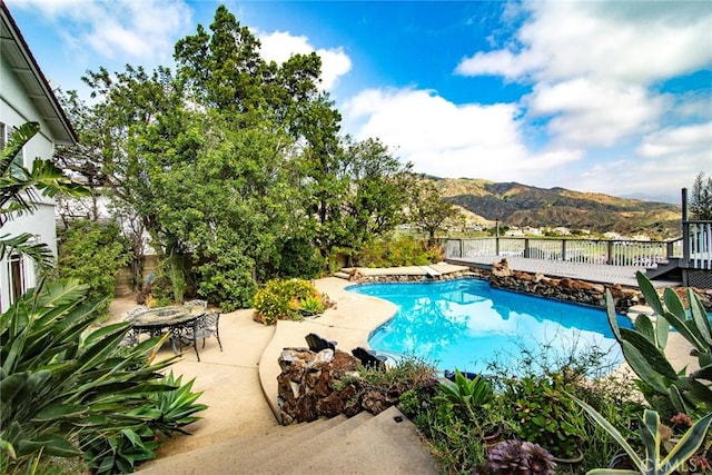 view of swimming pool featuring a fenced in pool, a patio area, a mountain view, and a fenced backyard