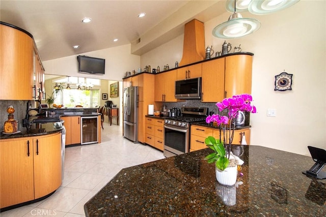 kitchen featuring lofted ceiling, beverage cooler, appliances with stainless steel finishes, and backsplash