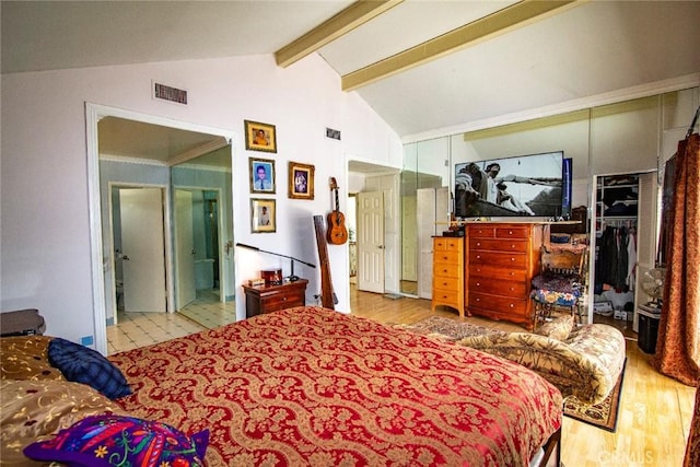 bedroom with lofted ceiling with beams, visible vents, a closet, and wood finished floors