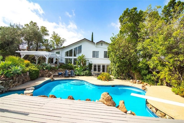 pool featuring a diving board, a patio, and a pergola