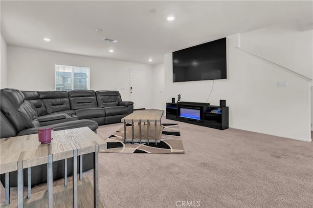 living area featuring recessed lighting, visible vents, and carpet