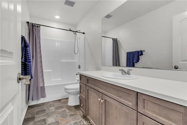 bathroom featuring vanity, visible vents, stone finish floor, toilet, and shower / tub combo with curtain