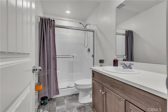 bathroom featuring vanity, toilet, and a stall shower