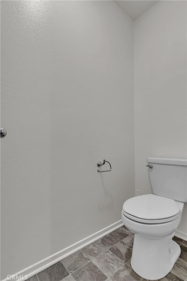 bathroom with toilet and baseboards