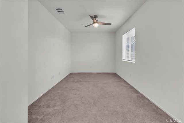 empty room with visible vents, baseboards, carpet, and a ceiling fan