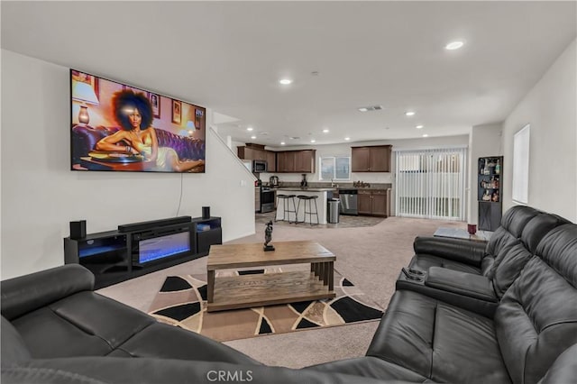 living room featuring recessed lighting, visible vents, and light carpet