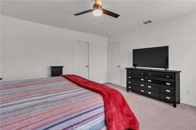 carpeted bedroom featuring baseboards, visible vents, and ceiling fan