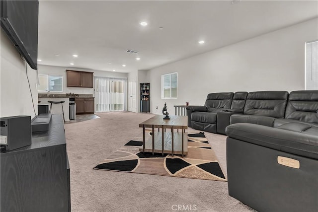 living room featuring recessed lighting, light colored carpet, and visible vents