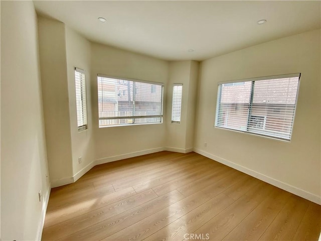 empty room featuring wood finished floors and baseboards