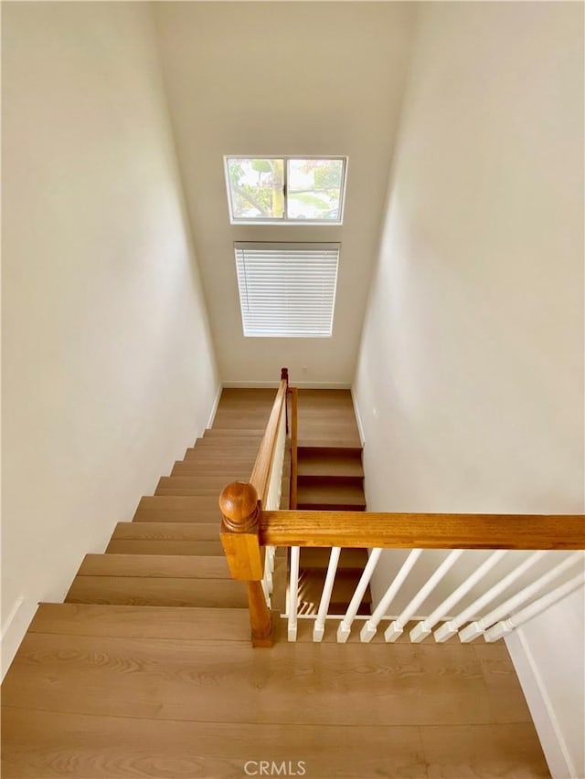 stairs with wood finished floors and baseboards