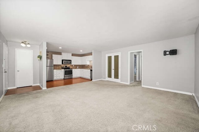 unfurnished living room featuring recessed lighting, baseboards, and carpet floors