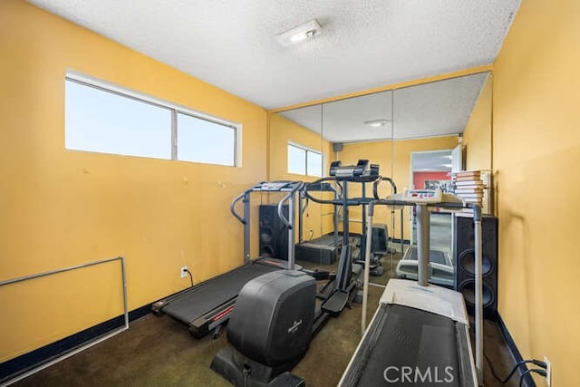 workout room featuring carpet floors and a textured ceiling