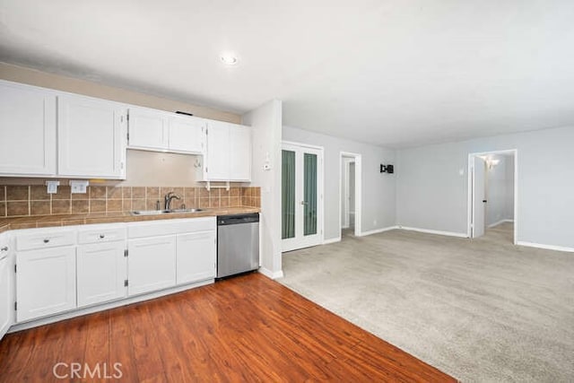 kitchen with dishwasher, white cabinets, tile countertops, and a sink