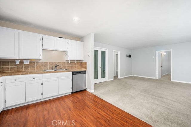 kitchen featuring dishwasher, white cabinetry, a sink, and tile countertops