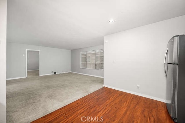unfurnished living room featuring baseboards