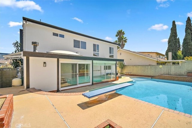 back of house with a patio area, a fenced in pool, a fenced backyard, and stucco siding