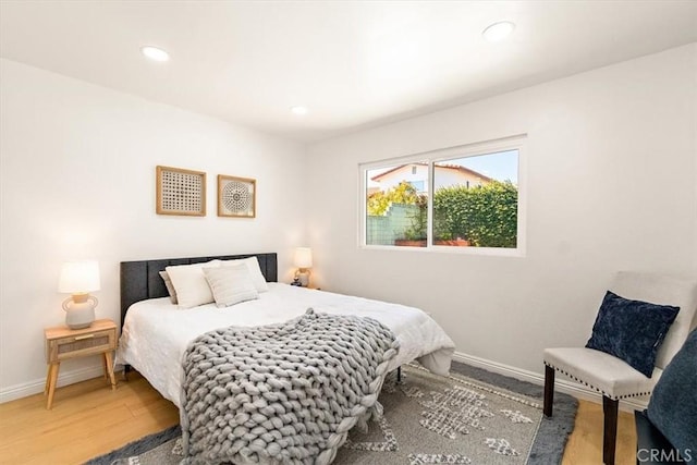 bedroom with recessed lighting, wood finished floors, and baseboards