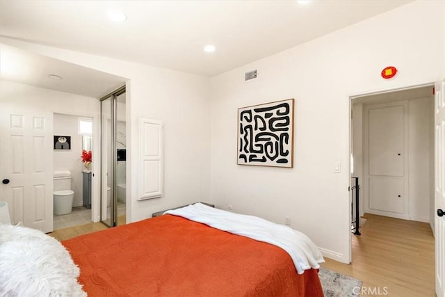 bedroom with visible vents, ensuite bath, recessed lighting, light wood-style floors, and baseboards