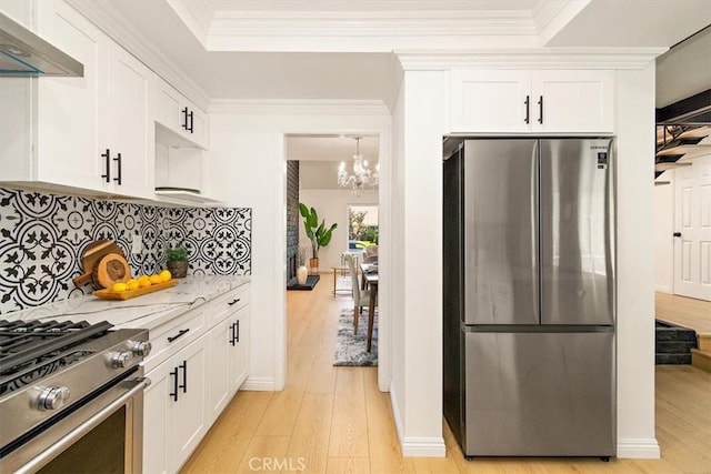 kitchen with white cabinets, light wood-style floors, under cabinet range hood, and stainless steel appliances