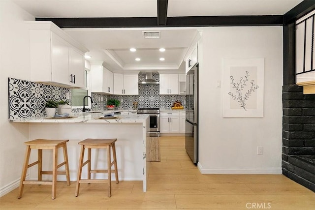 kitchen featuring visible vents, wall chimney range hood, stainless steel electric stove, a peninsula, and a raised ceiling