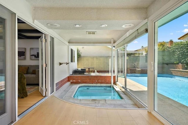 view of swimming pool with an in ground hot tub