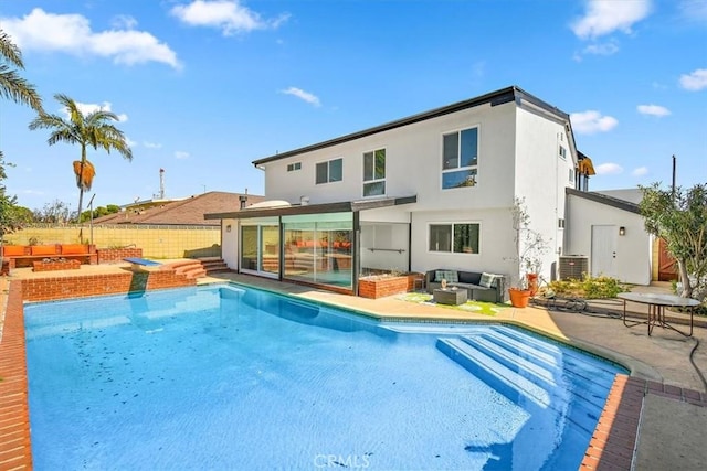 rear view of property featuring a patio, a fenced in pool, fence, stucco siding, and outdoor lounge area