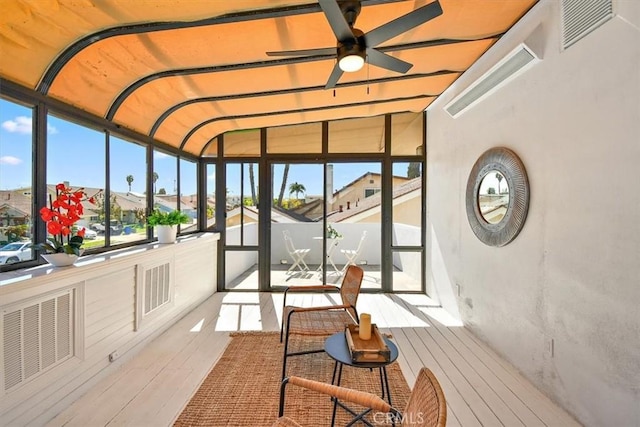 sunroom featuring visible vents, a residential view, and ceiling fan