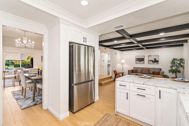 kitchen featuring white cabinets, light wood finished floors, open floor plan, and freestanding refrigerator